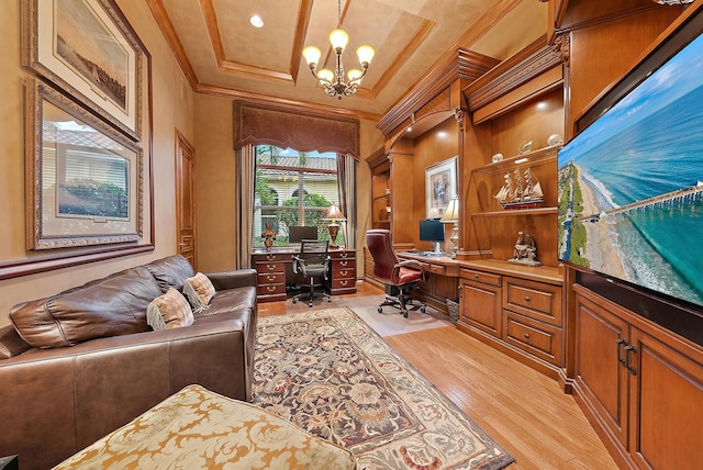 home office with crown molding, an inviting chandelier, light hardwood / wood-style floors, and built in desk