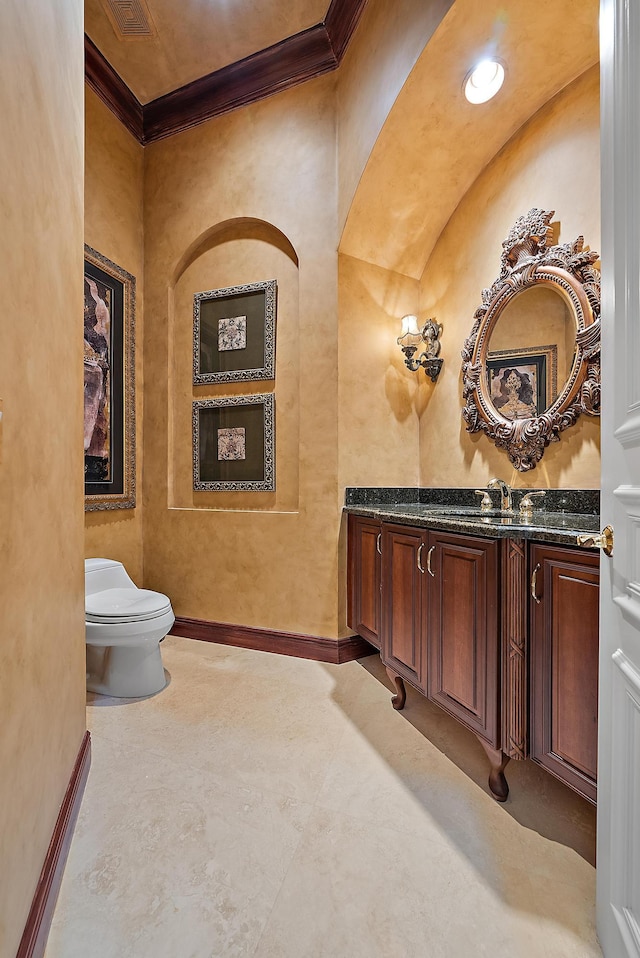 bathroom with tile patterned flooring, crown molding, toilet, and vanity