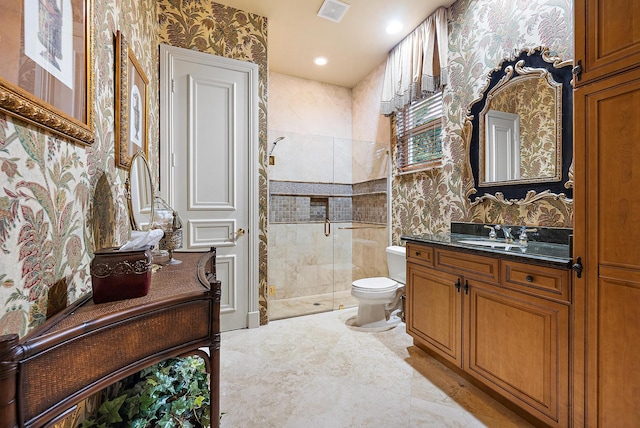 bathroom with vanity, tile patterned floors, a shower with shower door, tile walls, and toilet