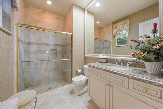 bathroom featuring tile patterned flooring, a shower with shower door, vanity, and toilet