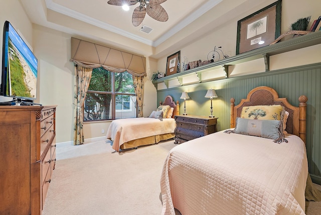 bedroom with ceiling fan, a raised ceiling, crown molding, and light colored carpet