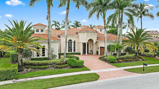 mediterranean / spanish house with a front yard and a garage