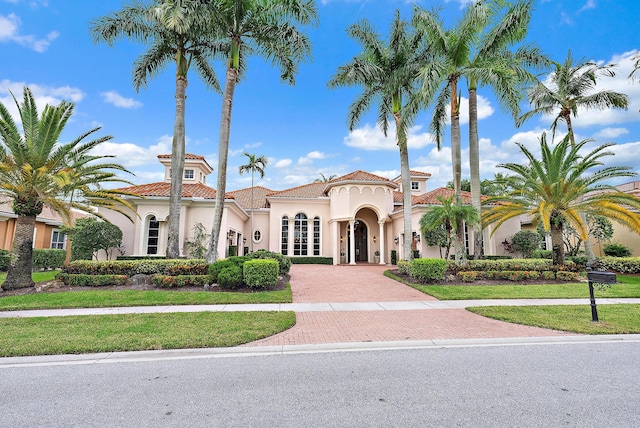 mediterranean / spanish home featuring a front lawn