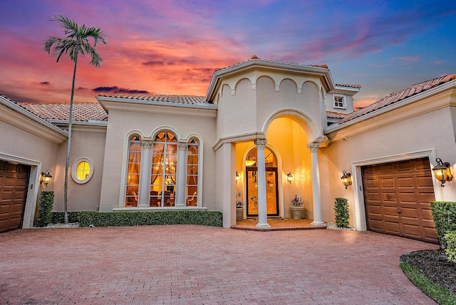 mediterranean / spanish house featuring a garage and french doors