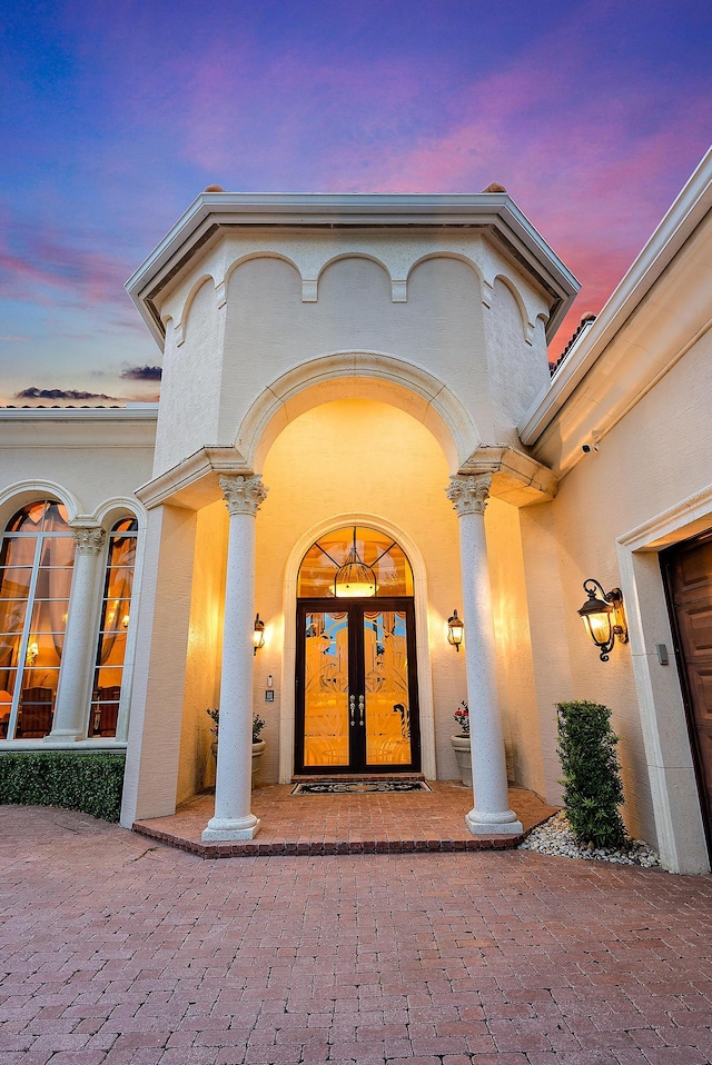 exterior entry at dusk featuring french doors