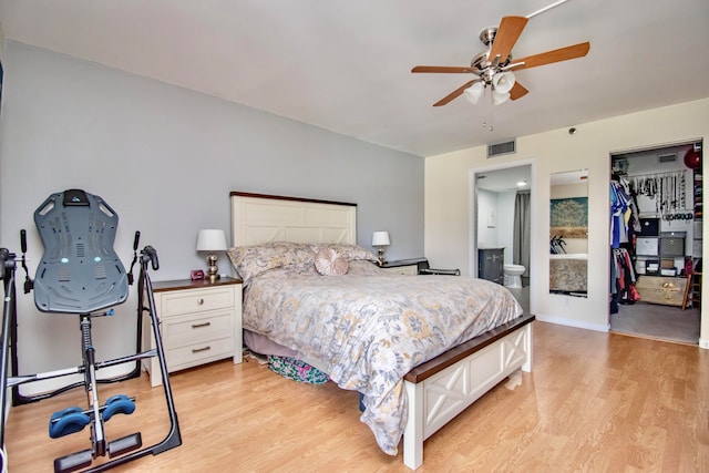 bedroom featuring ceiling fan, light wood-type flooring, a closet, and ensuite bath