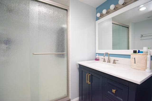 bathroom featuring vanity and a shower with shower door