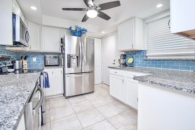 kitchen featuring ceiling fan, decorative backsplash, white cabinetry, and stainless steel appliances