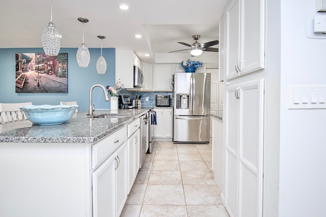 kitchen featuring light tile patterned floors, decorative light fixtures, ceiling fan, stainless steel appliances, and white cabinets