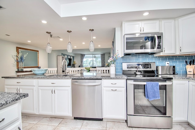 kitchen with light tile patterned flooring, appliances with stainless steel finishes, tasteful backsplash, and stone counters