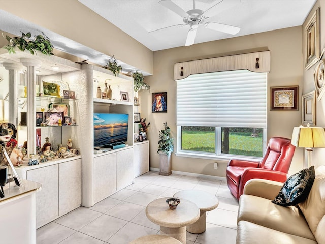 living room with light tile patterned floors, baseboards, and a ceiling fan