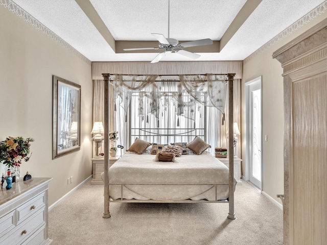 bedroom featuring light colored carpet, a textured ceiling, and a raised ceiling