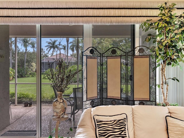 view of gate with glass enclosure and a patio area