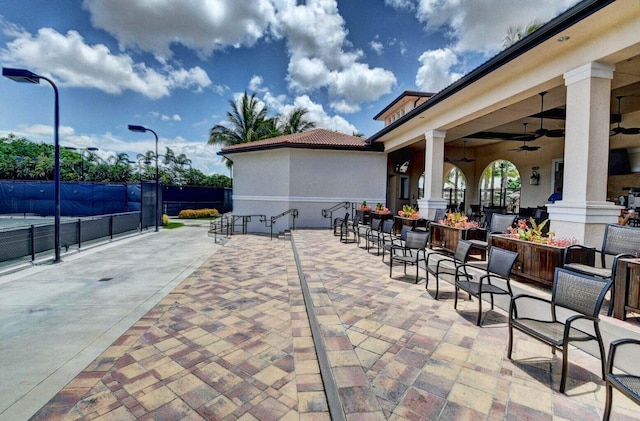 view of patio with ceiling fan and fence