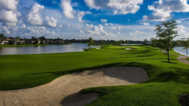 view of property's community with a lawn, a water view, and view of golf course