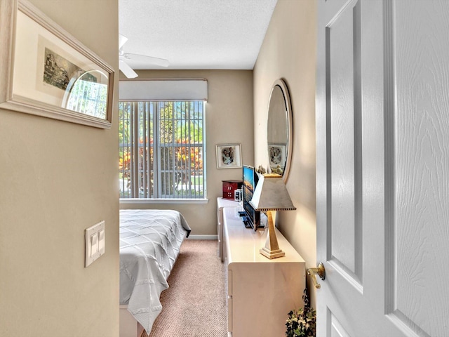 bedroom featuring a ceiling fan, baseboards, carpet floors, and a textured ceiling