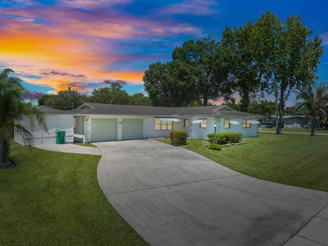 ranch-style house with a yard and a garage