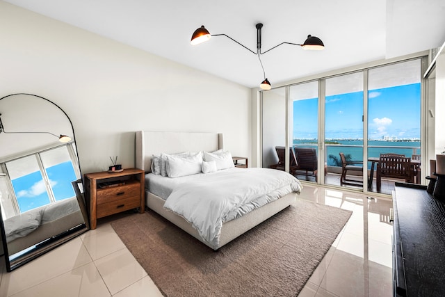 tiled bedroom featuring a water view and access to outside