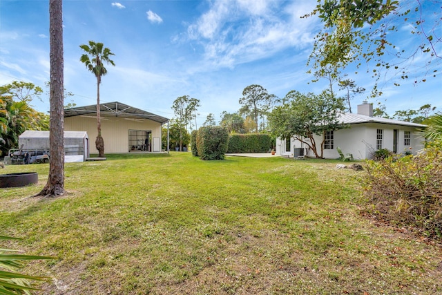 view of yard featuring central AC and a lanai