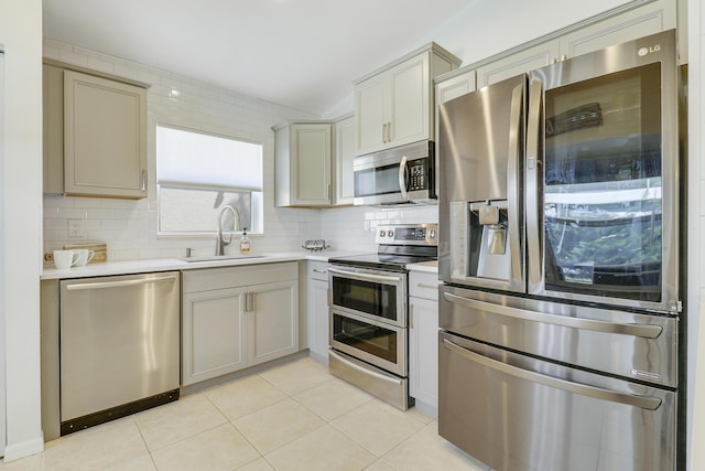 kitchen with stainless steel appliances, a sink, light countertops, and decorative backsplash