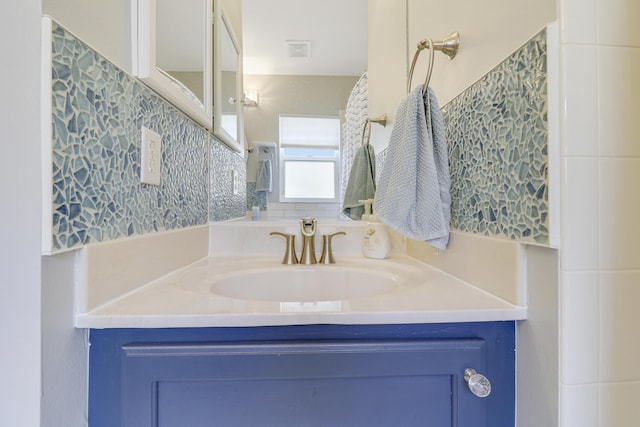 bathroom featuring visible vents, vanity, and tile walls