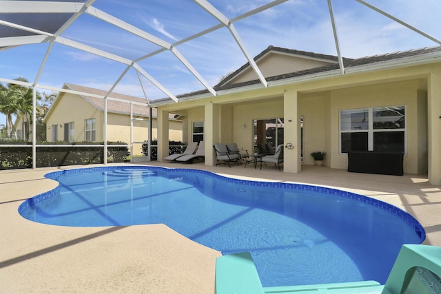 outdoor pool featuring glass enclosure and a patio area