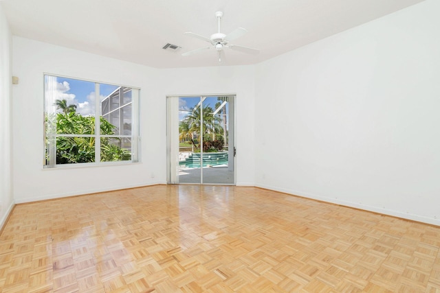 empty room with light parquet flooring and ceiling fan