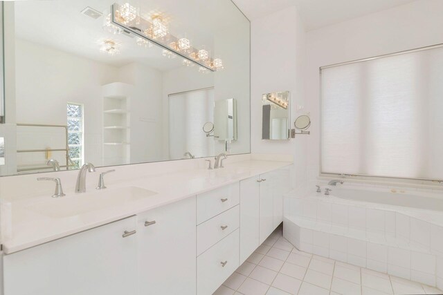 bathroom with vanity, tiled bath, and tile patterned flooring