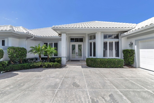 doorway to property featuring french doors and a garage