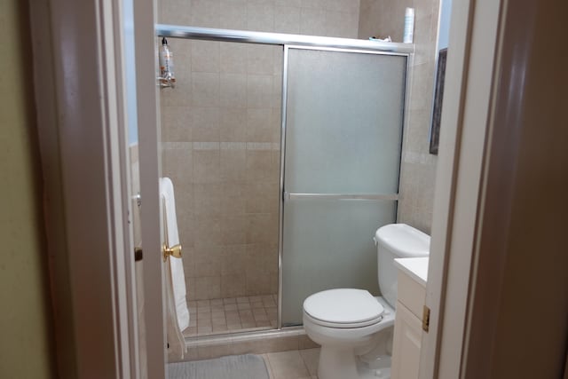 bathroom with tile patterned floors, toilet, walk in shower, and vanity