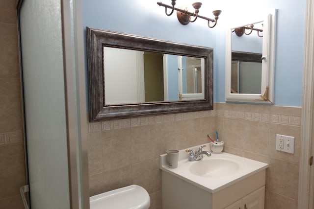 bathroom with a notable chandelier, decorative backsplash, vanity, tile walls, and toilet