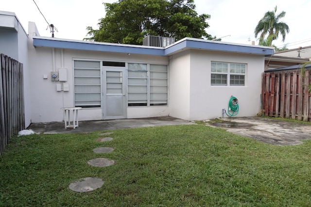 rear view of house with a patio and a yard