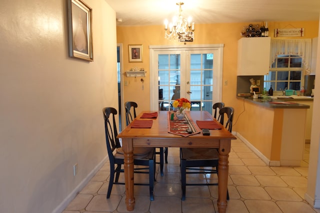 tiled dining space featuring french doors and a chandelier