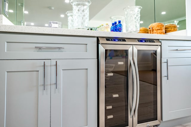 interior details with stainless steel refrigerator, white cabinetry, and an inviting chandelier