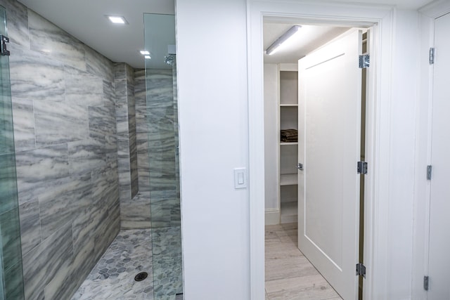 bathroom featuring hardwood / wood-style flooring and a shower with door