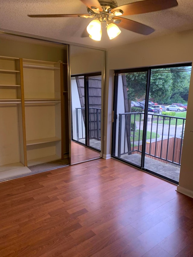 unfurnished bedroom featuring ceiling fan, hardwood / wood-style flooring, and a textured ceiling