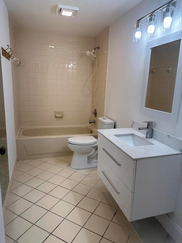 full bathroom featuring tile patterned flooring, vanity, tiled shower / bath combo, and toilet