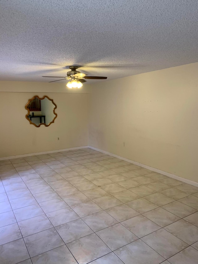 spare room featuring ceiling fan, a textured ceiling, and light tile patterned floors