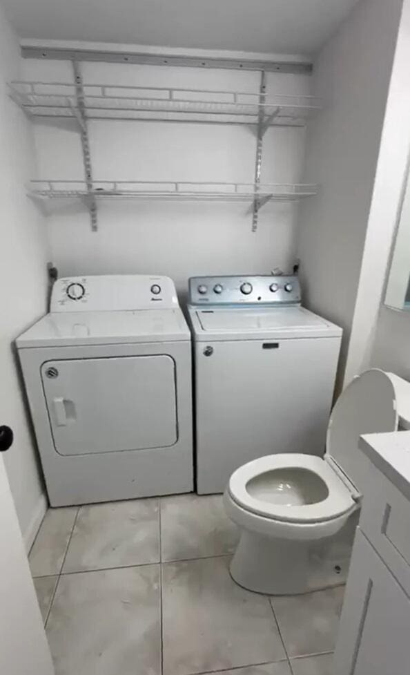 laundry area featuring washing machine and dryer and light tile patterned floors