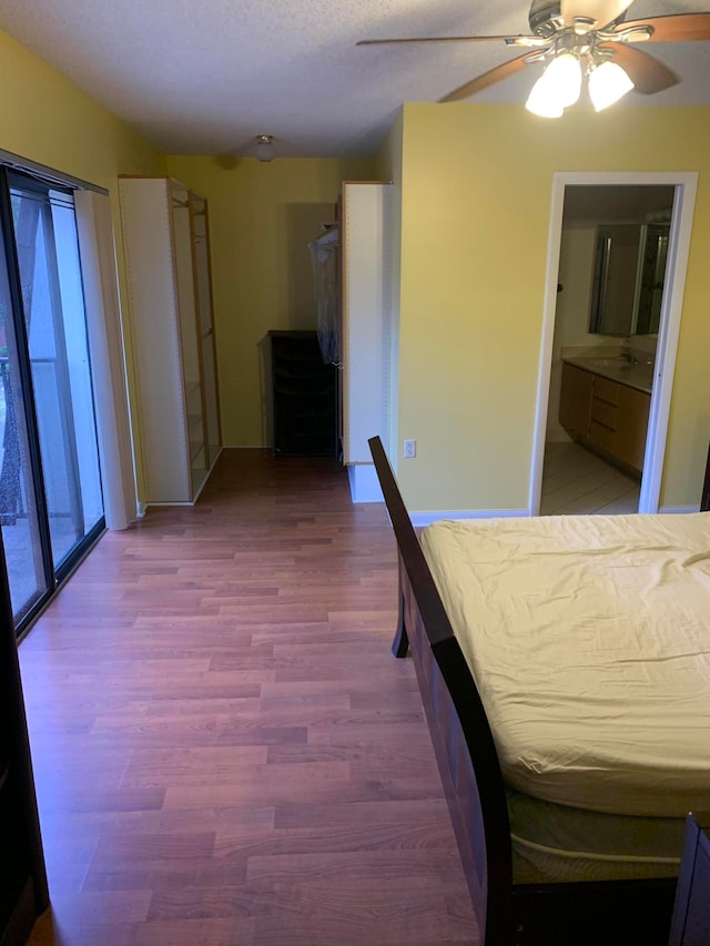 unfurnished bedroom featuring ceiling fan, hardwood / wood-style floors, and sink