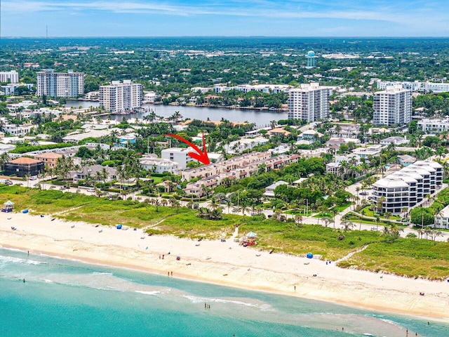 birds eye view of property featuring a beach view and a water view