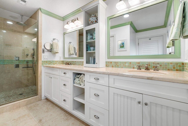 bathroom featuring a shower with shower door, a textured ceiling, tasteful backsplash, and vanity