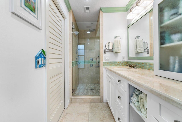 bathroom with tile patterned flooring, walk in shower, a textured ceiling, and vanity