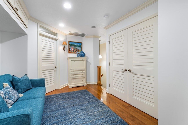 living area with ornamental molding and light hardwood / wood-style flooring