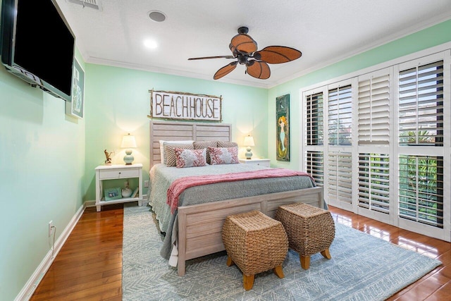 bedroom featuring wood-type flooring, crown molding, and ceiling fan