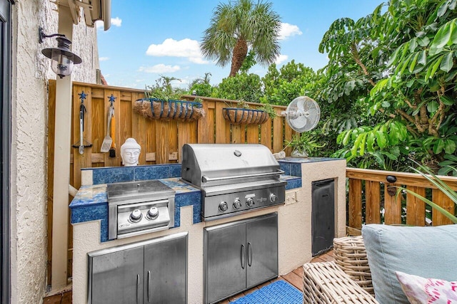 view of patio / terrace featuring a wooden deck, an outdoor kitchen, and area for grilling