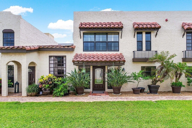 mediterranean / spanish-style house with a front yard