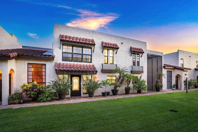 mediterranean / spanish-style house with a front lawn