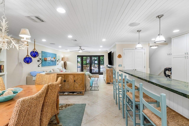 tiled dining room with crown molding, ceiling fan, and french doors