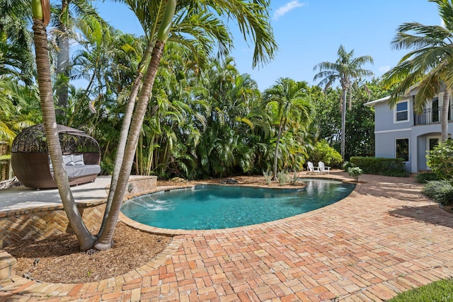 view of swimming pool featuring pool water feature and a patio area